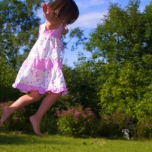 "pembe kıyafetli kız havada zıplıyor."